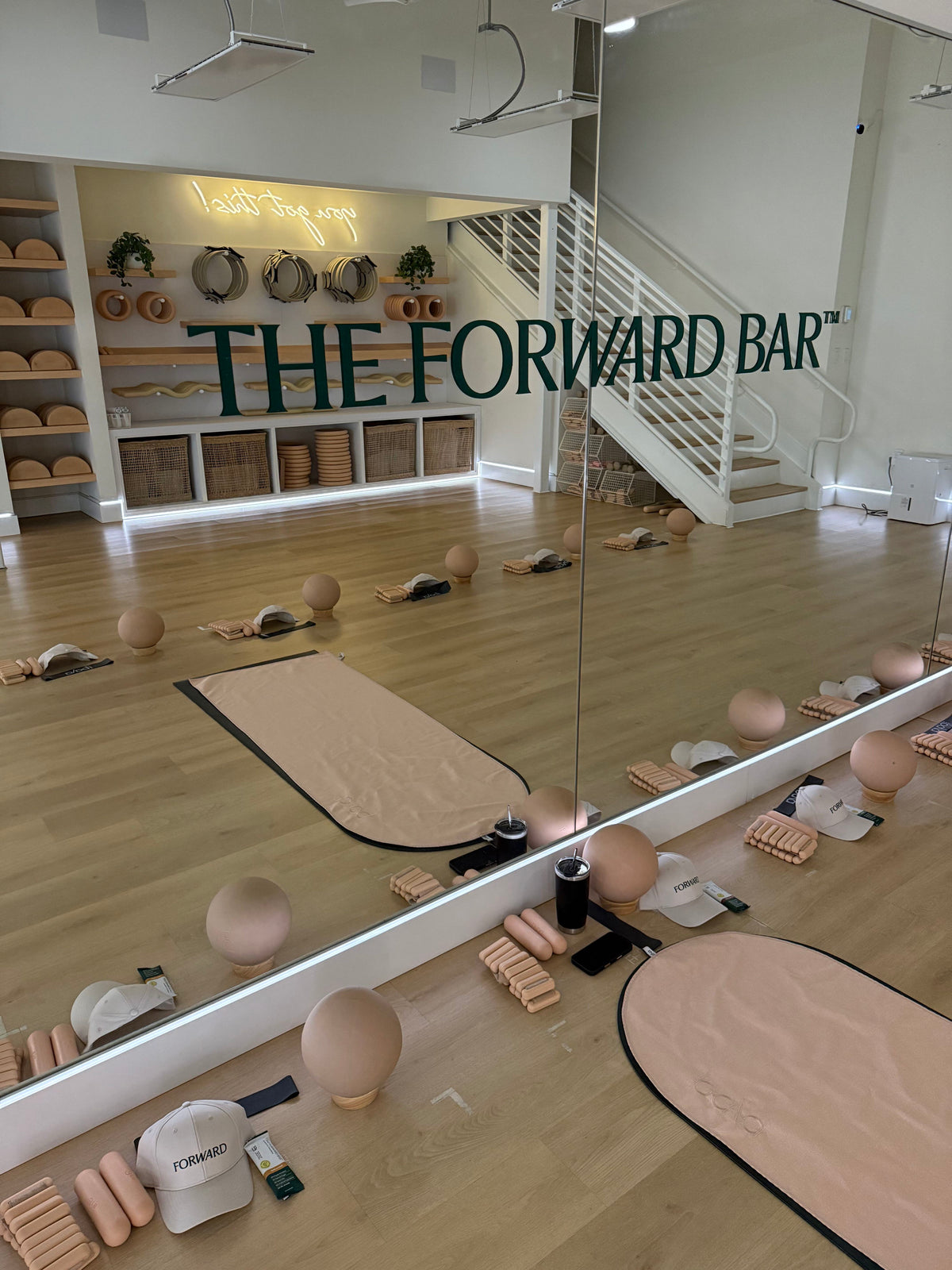 Workout class set up with a branded "The Forward Bar" decal on the mirror