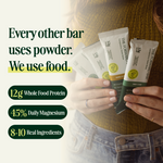 Person holding protein bars with text about ingredients and benefits - view 2